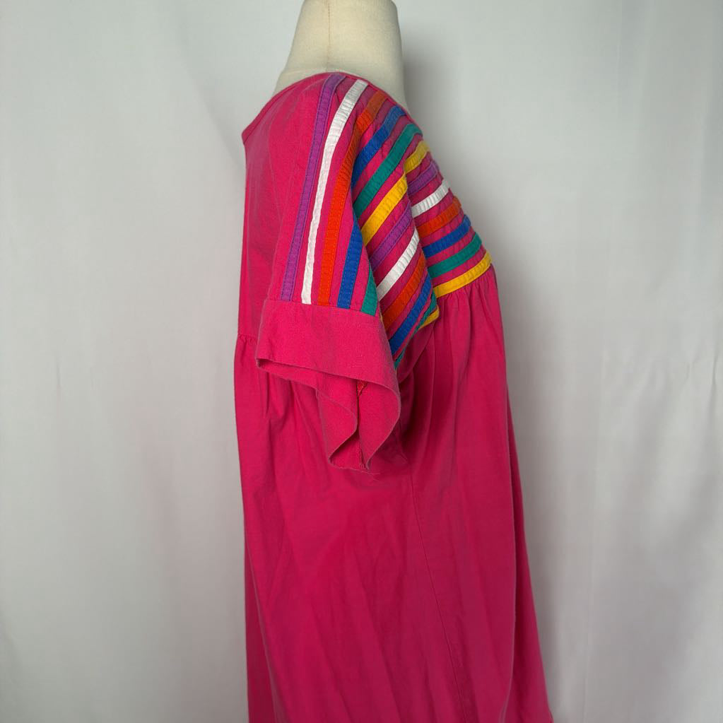 Pink ruffled maxi dress with striped design on a mannequin in front of a white wall. 