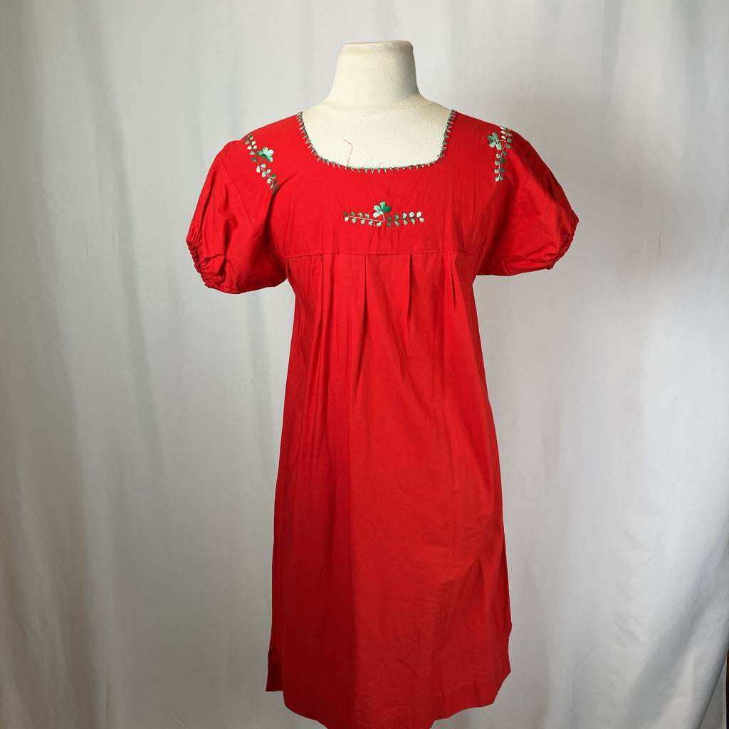 Red dress with floral embroidery on a mannequin against a white background