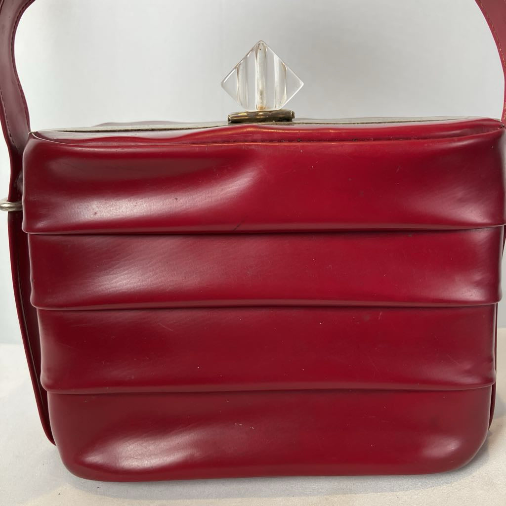 Red handbag with a clear crystal handle on a white background