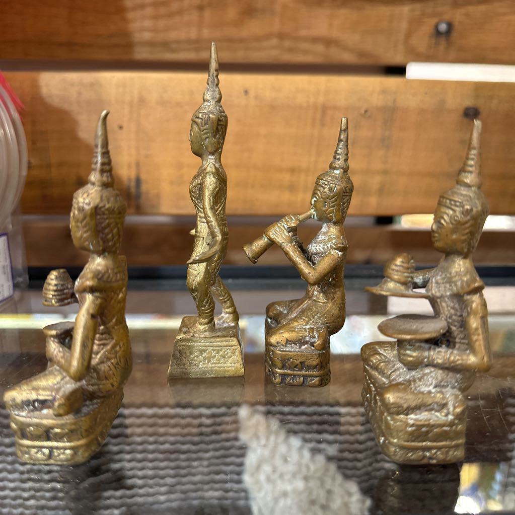 Set of gold figurines on a reflective surface with a wooden background