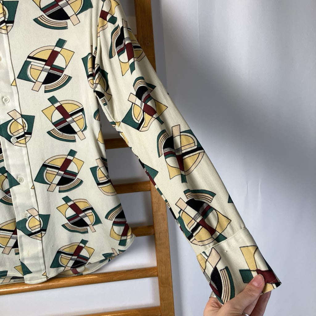 Shirt with geometric pattern held up against a plain background