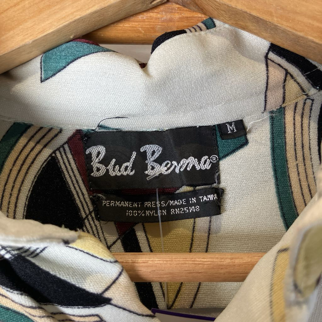 Close-up of a Bud Bernie label on a patterned shirt with a wooden hanger.