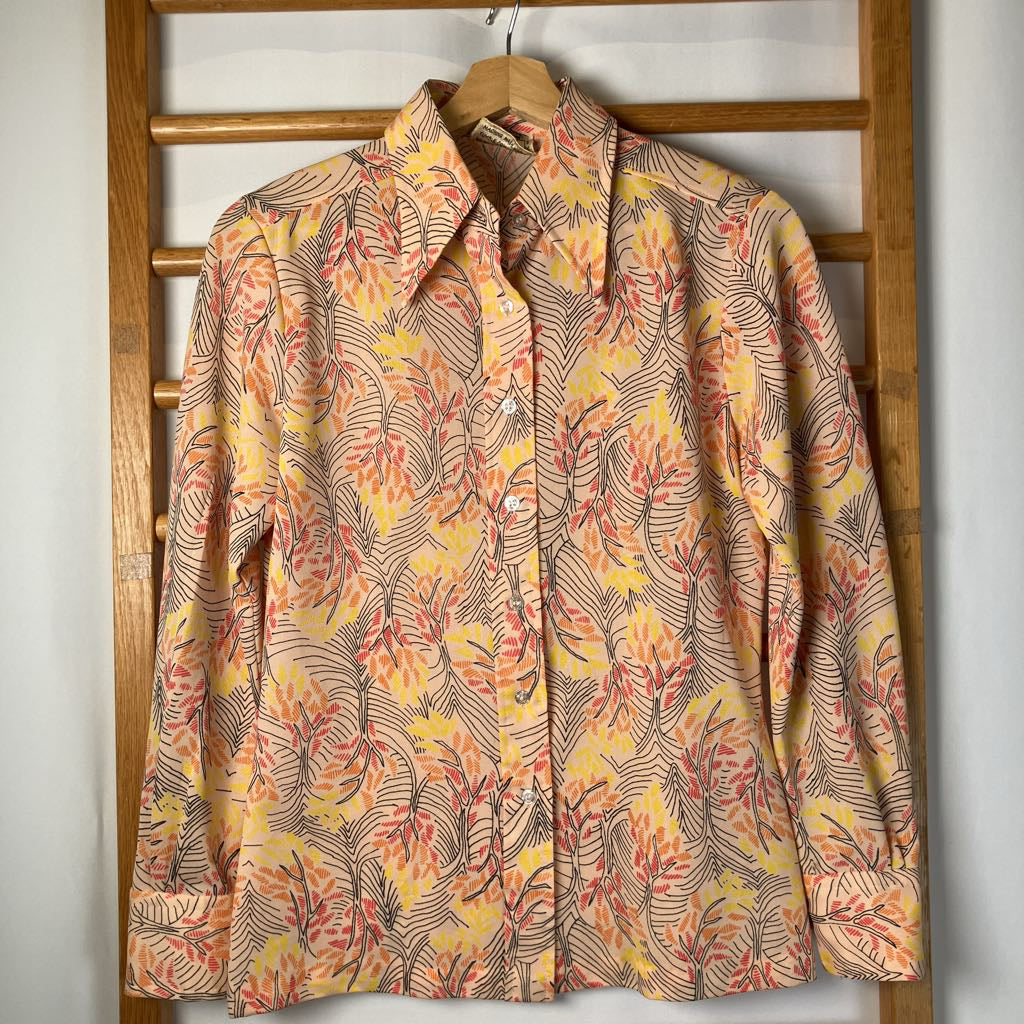 Floral patterned shirt on a wooden hanger against a wooden panel background