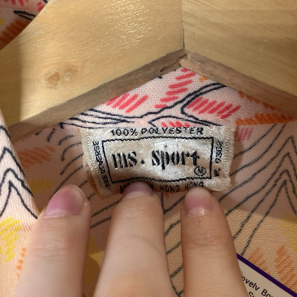 Close-up of a fabric label with text and a hand holding it.