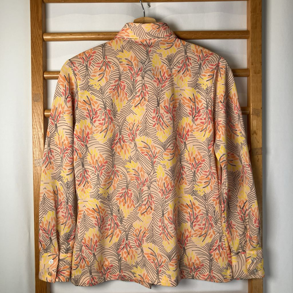 Floral patterned shirt on a wooden hanger against a white wall