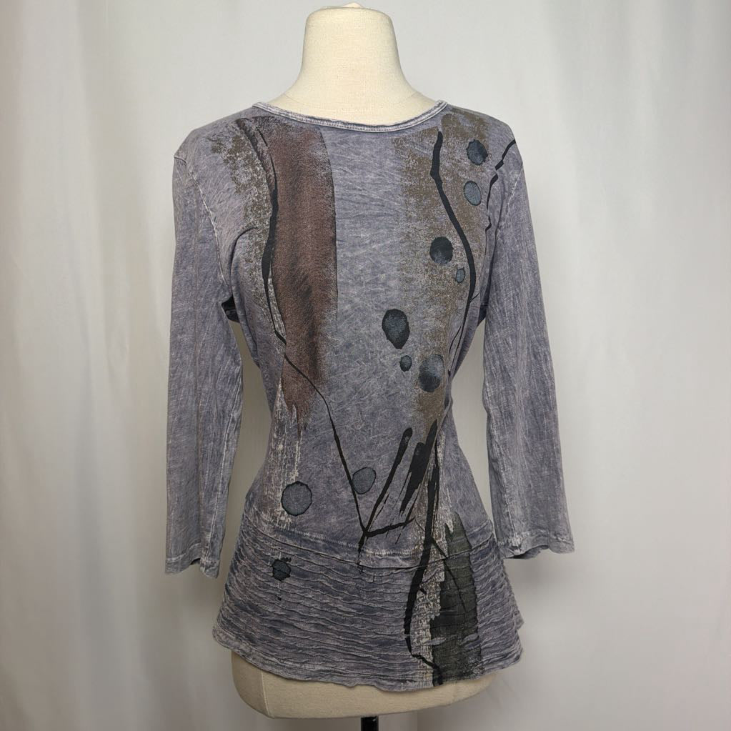 Gray tunic dress with an abstract design on a mannequin in front of a white wall. 