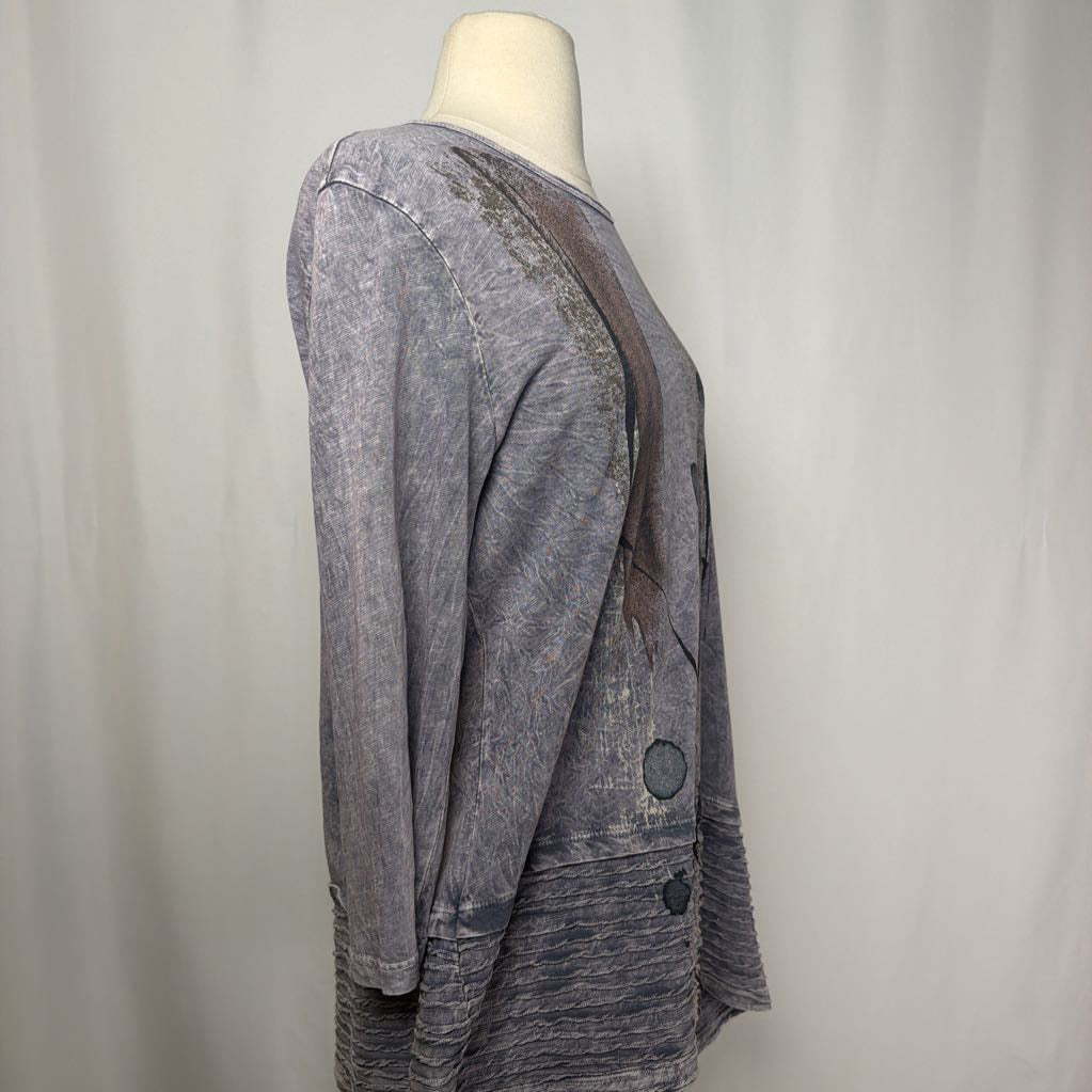 Gray tunic dress with an abstract design on a mannequin in front of a white wall. 