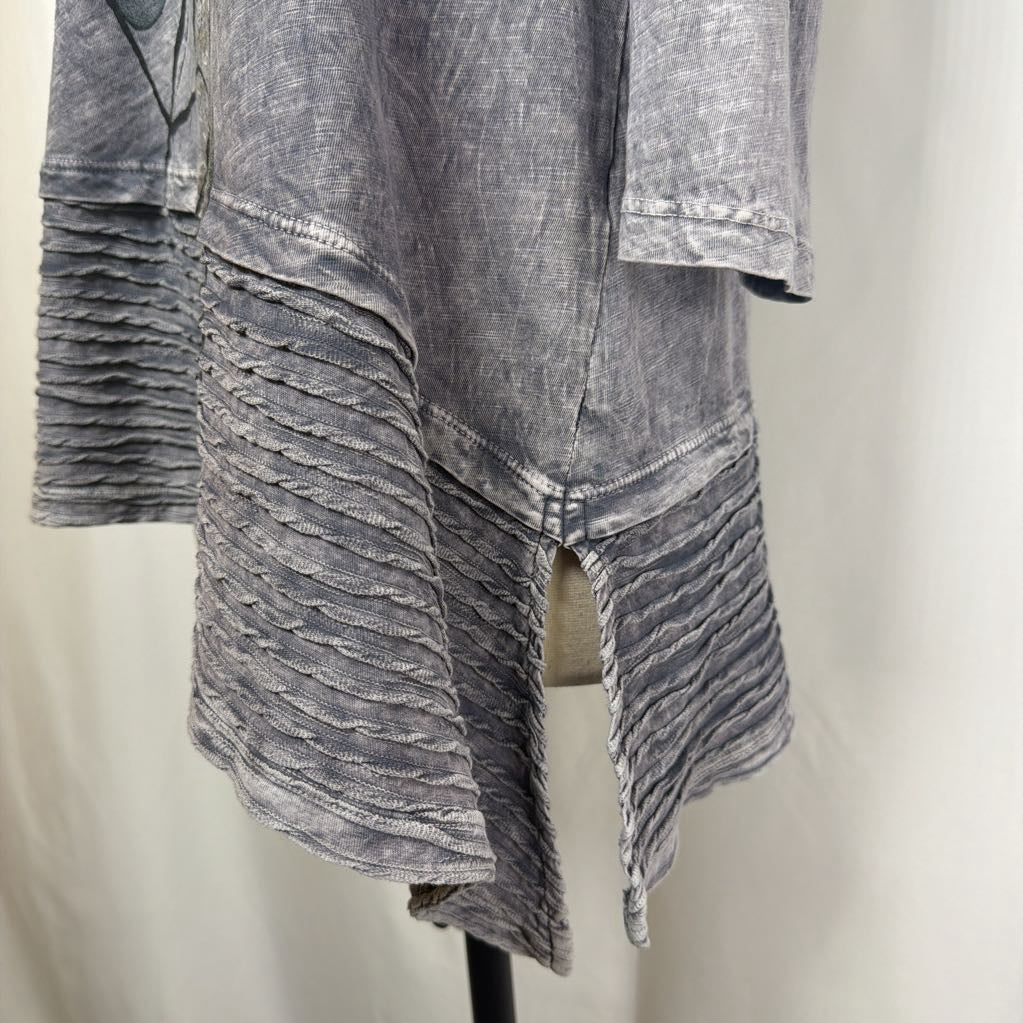 Gray tunic dress with an abstract design on a mannequin in front of a white wall. 