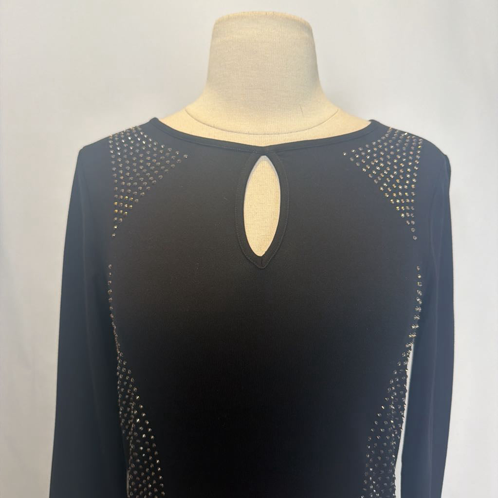 Black dress with rhinestone embellishments on a mannequin in front of a white wall.  