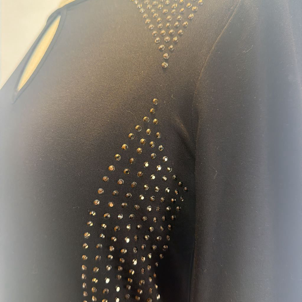 Black dress with rhinestone embellishments on a mannequin in front of a white wall.  