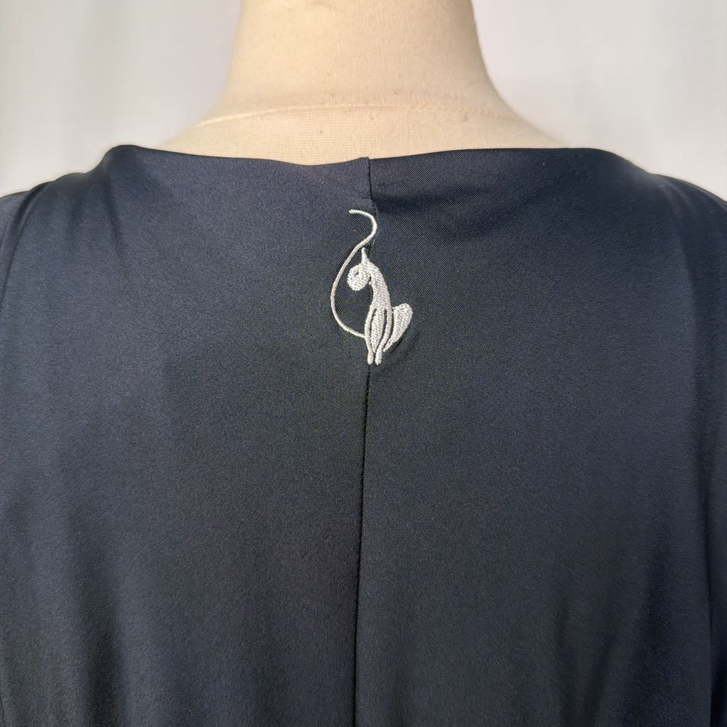 cat logo on back of black dress against white background