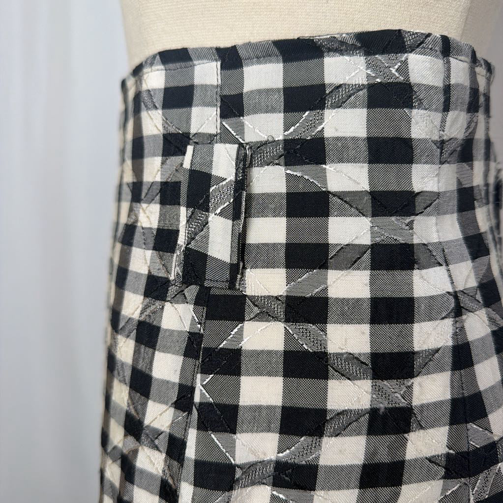 Black and white gingham skirt on a mannequin front of a white wall. 