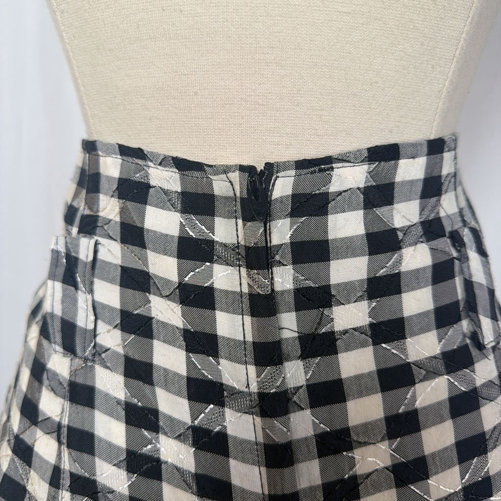 Black and white gingham skirt on a mannequin front of a white wall. 