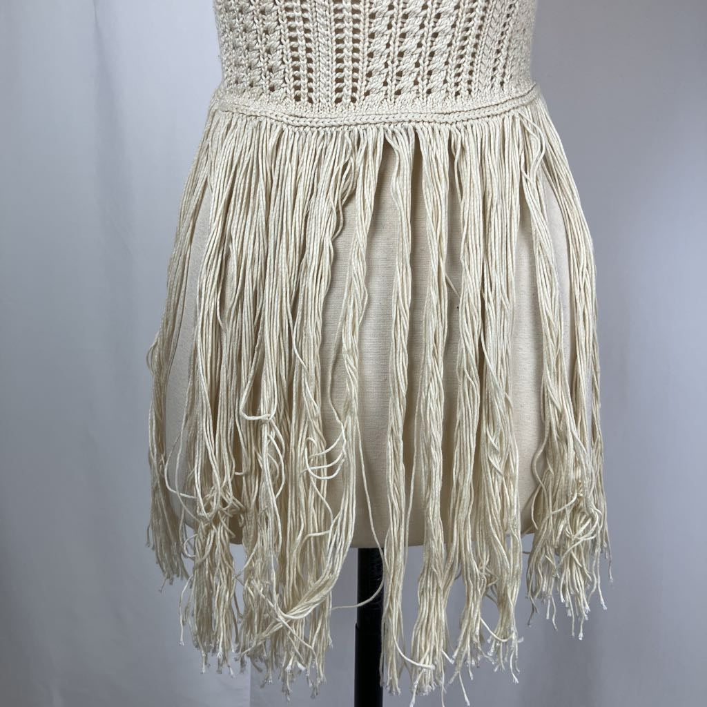 Beige fringe dress on a mannequin against a plain background