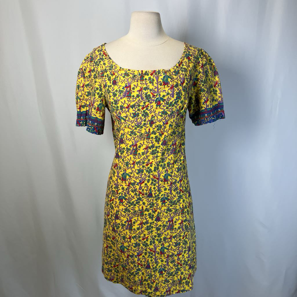Yellow floral dress on a mannequin against a plain background