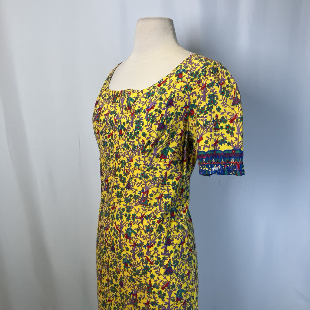 Yellow dress with colorful pattern on a mannequin against a plain background