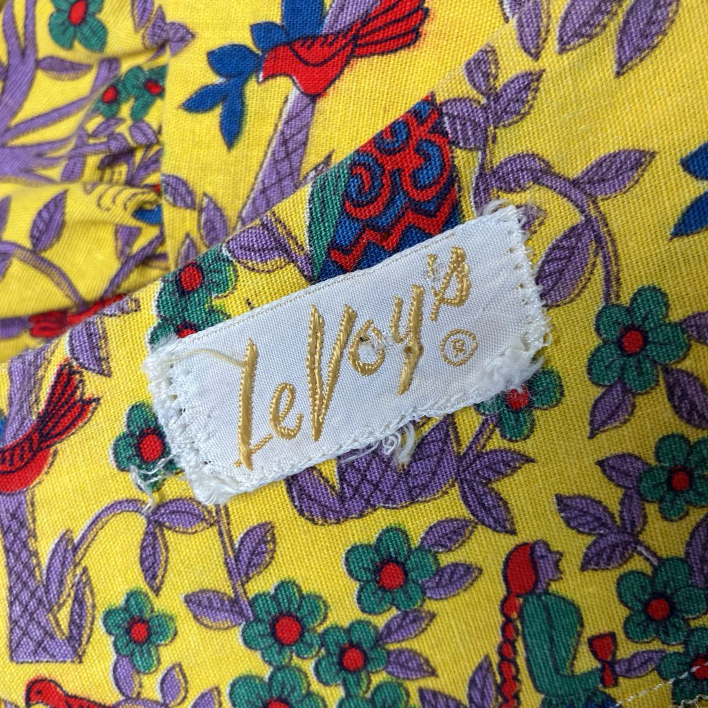 Fabric with colorful floral pattern and 'LeVoy's' label on a yellow background