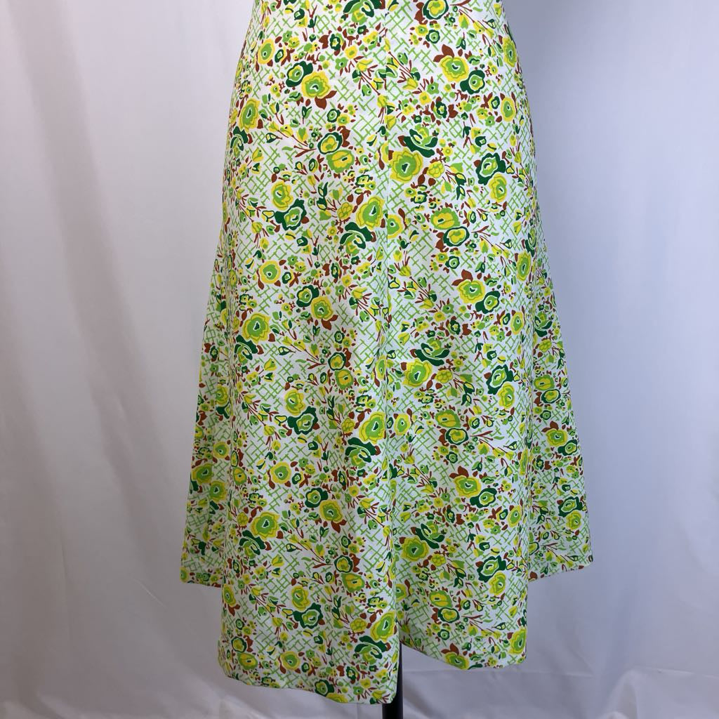 Floral patterned dress on mannequin against simple background