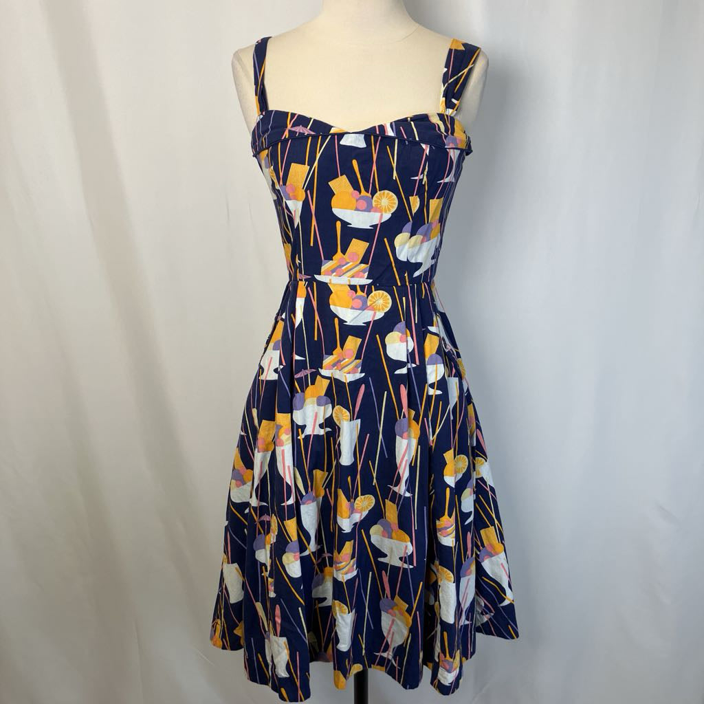 Dress with a colorful abstract pattern on a mannequin against a plain background