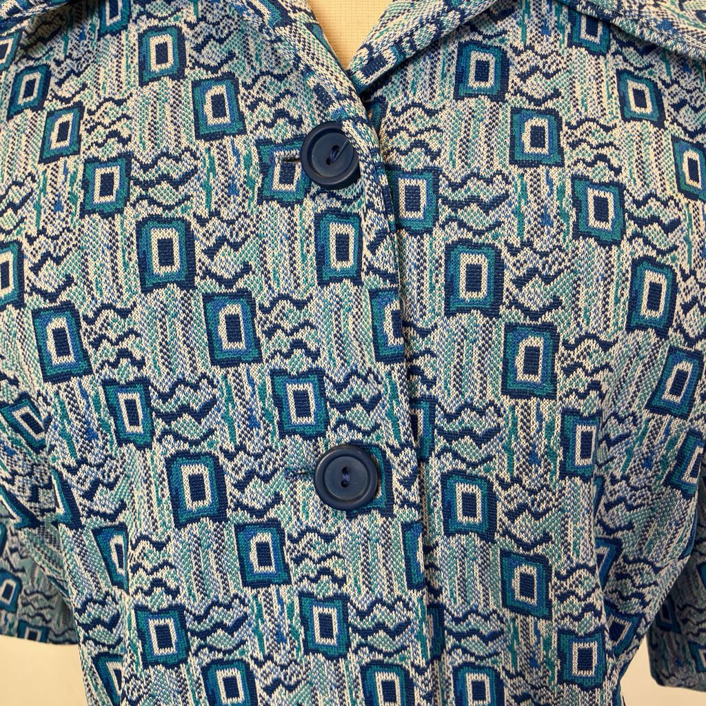 Closeup of the bust of the dress showing the dark blue buttons and geometric design