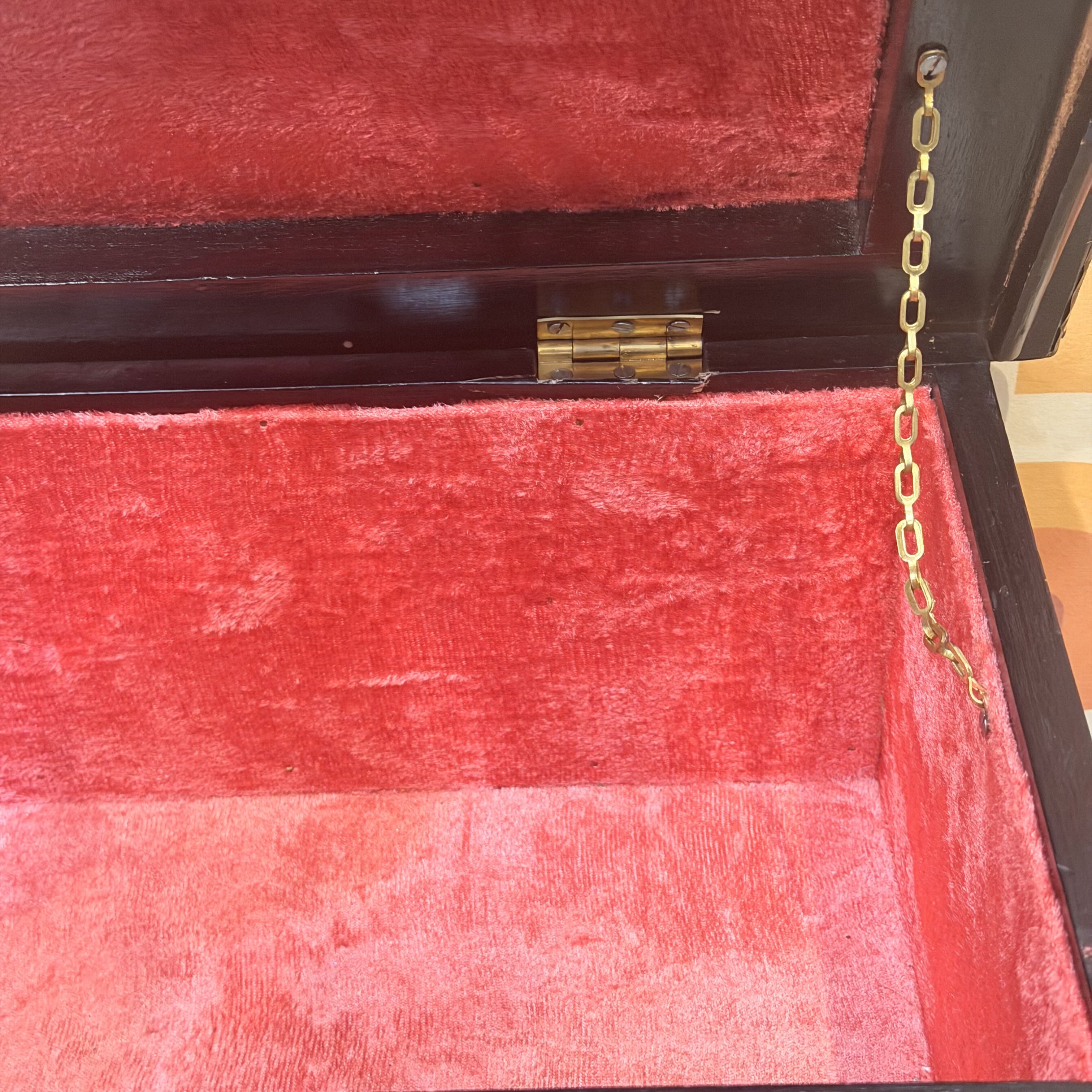 Red velvet box with a gold chain and clasp