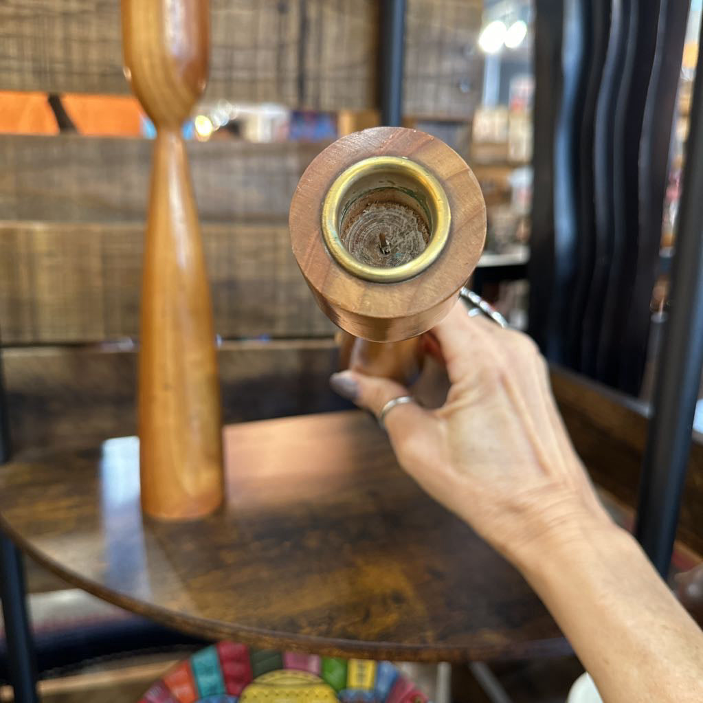 Hand holding a wooden candle holder with a blurred background