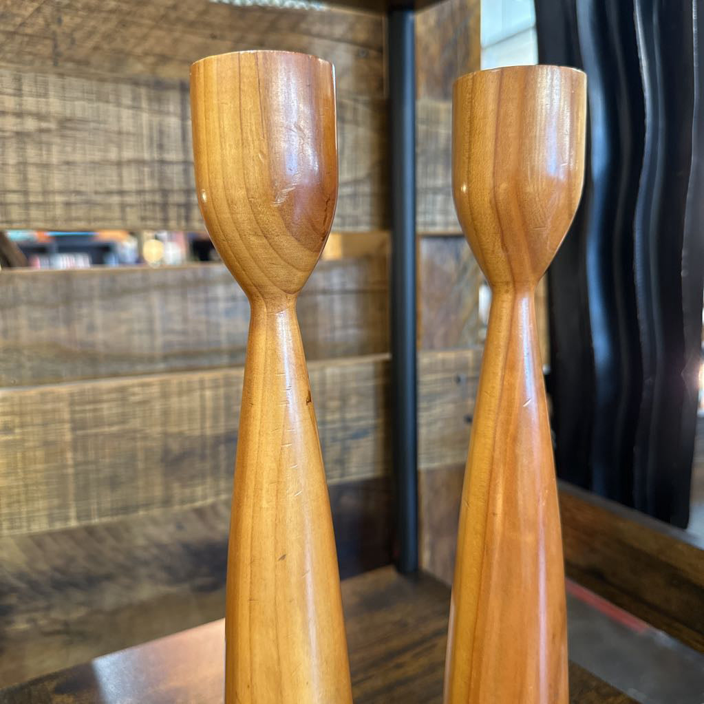 Two wooden ladles on a wooden surface with a blurred background