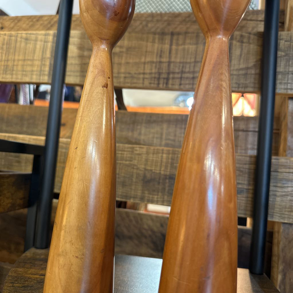 Two wooden spoons in front of a blurred indoor setting