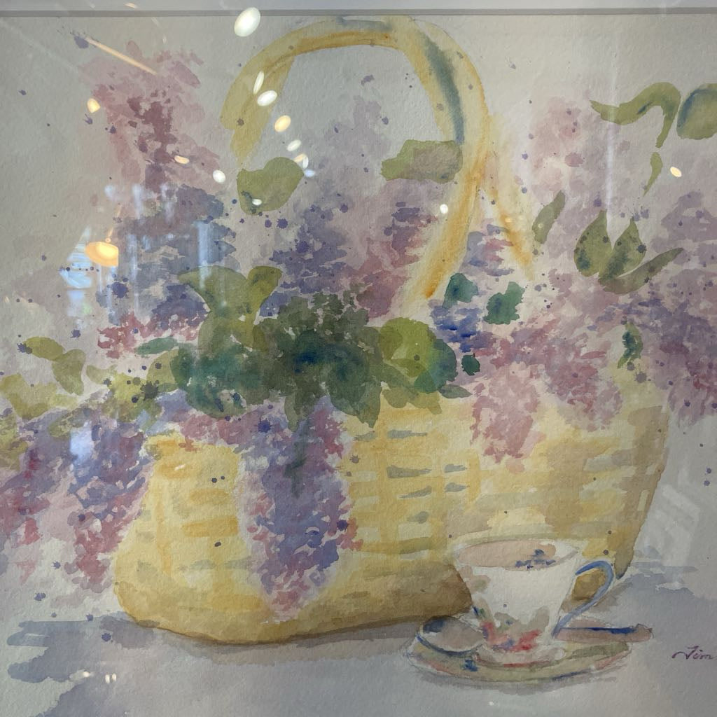 Watercolor painting of a yellow basket with flowers and a teacup on a floral background