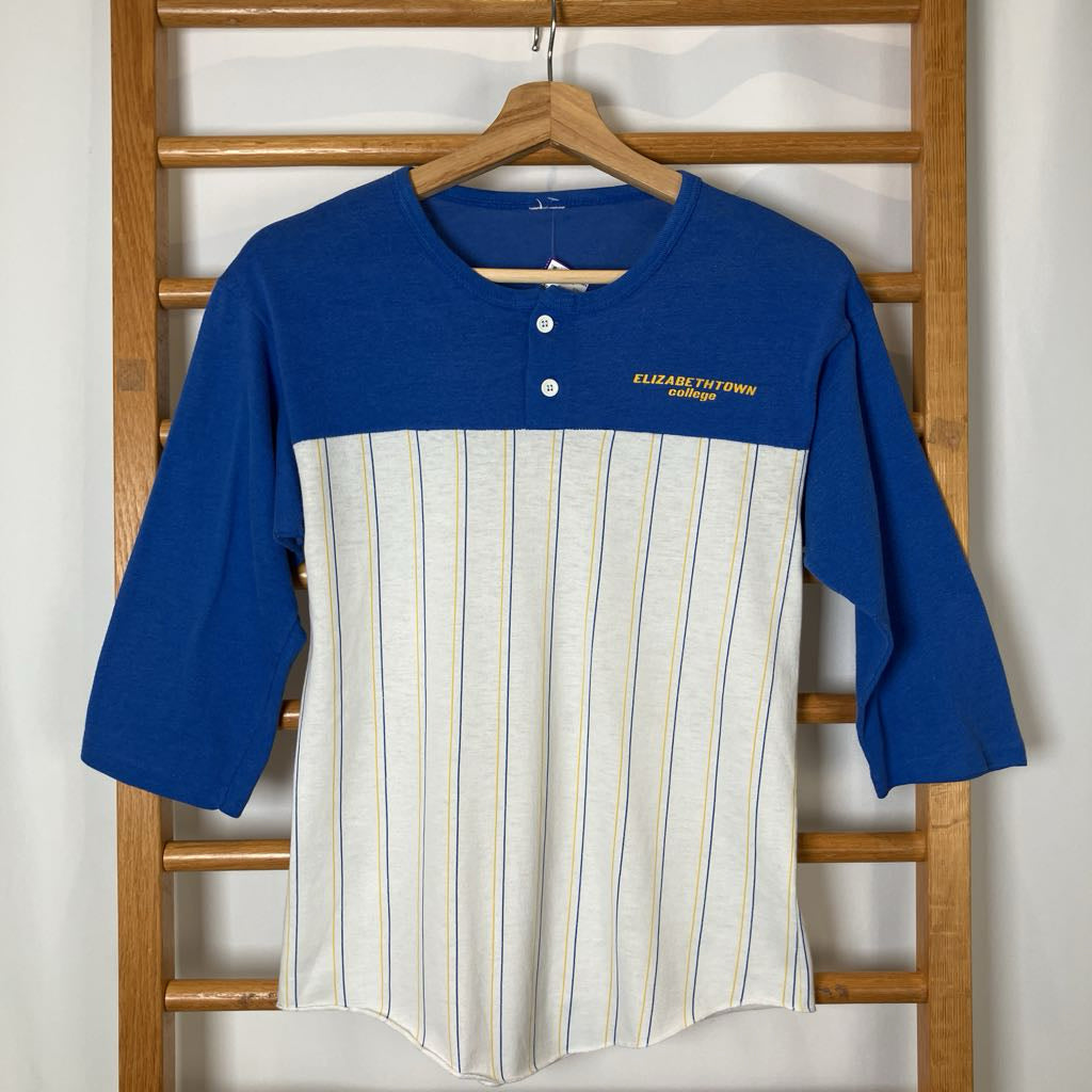 Blue and white baseball-style shirt on a wooden rack