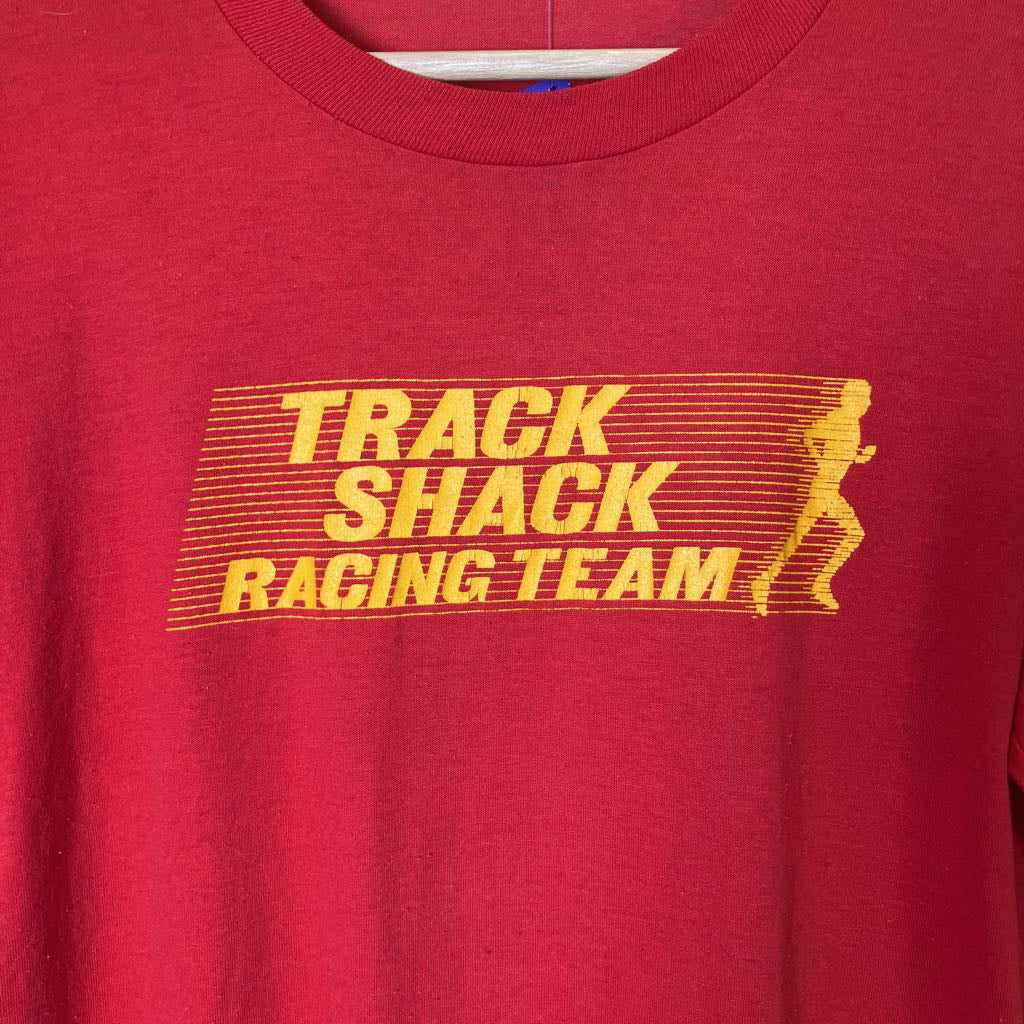 Red t-shirt with yellow 'Track Shack Racing Team' text and graphic on a red background
