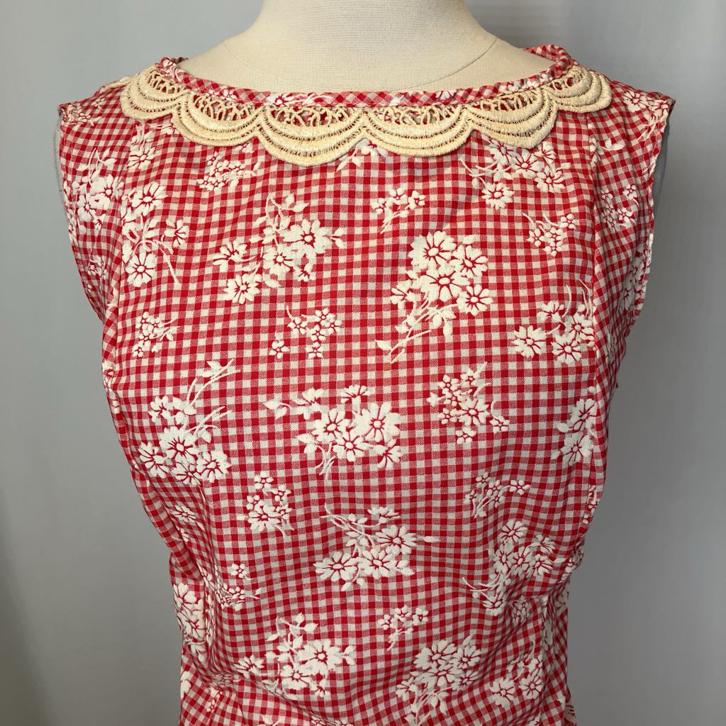 Red and white checkered dress with floral patterns on a mannequin against a gray background