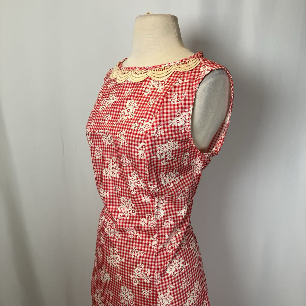 Red and white checkered dress with floral patterns on a mannequin against a gray background