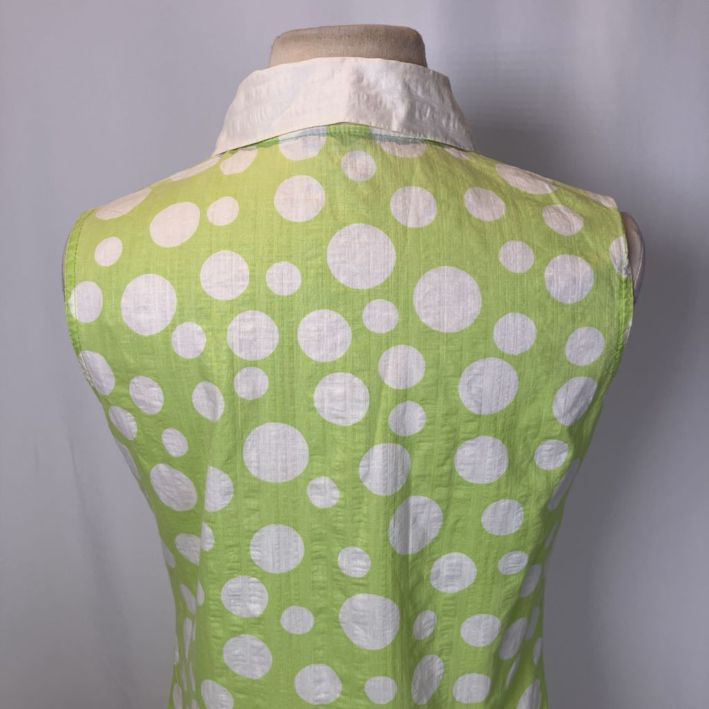 Green vest with white polka dots on a mannequin against a gray background