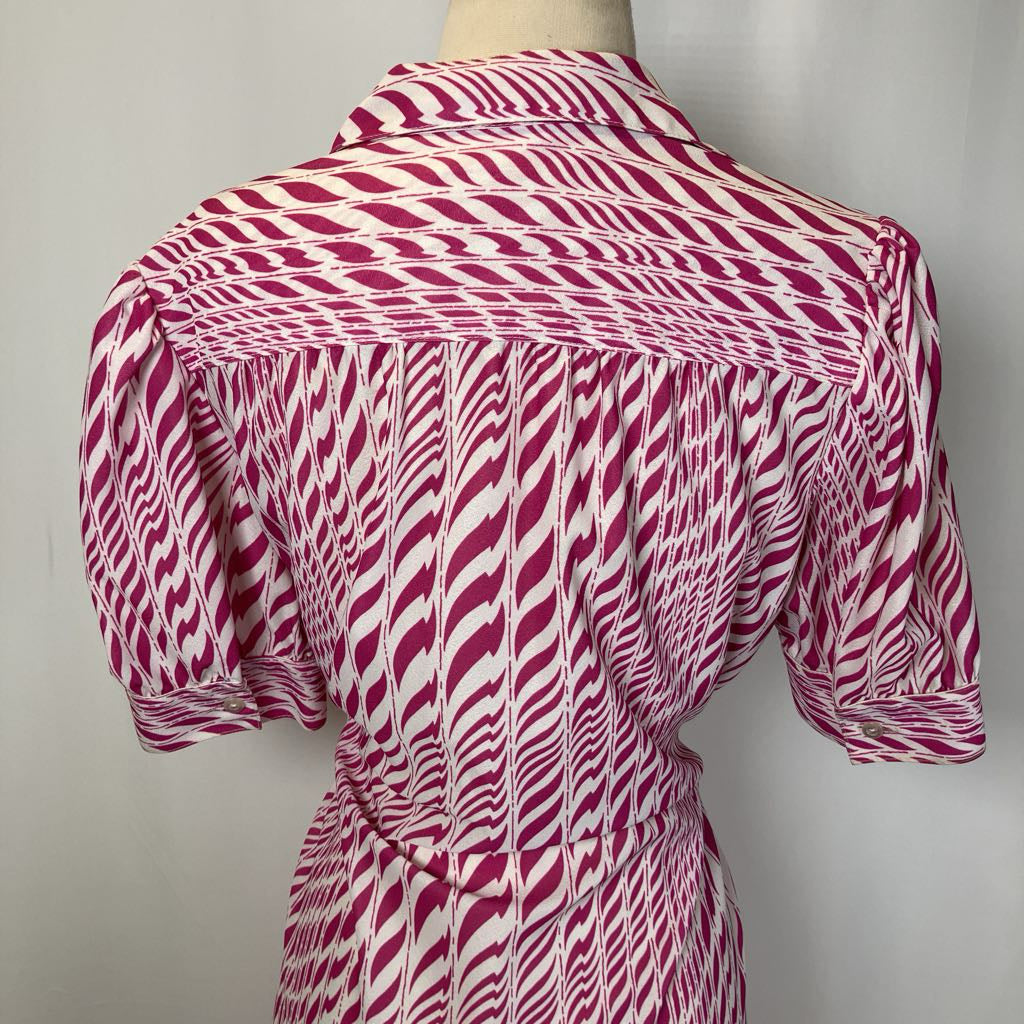 Mannequin wearing a pink and white patterned dress against a plain background