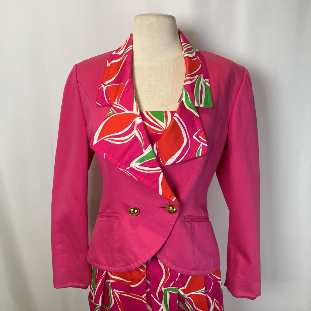 Pink suit with floral pattern on a mannequin against a plain background