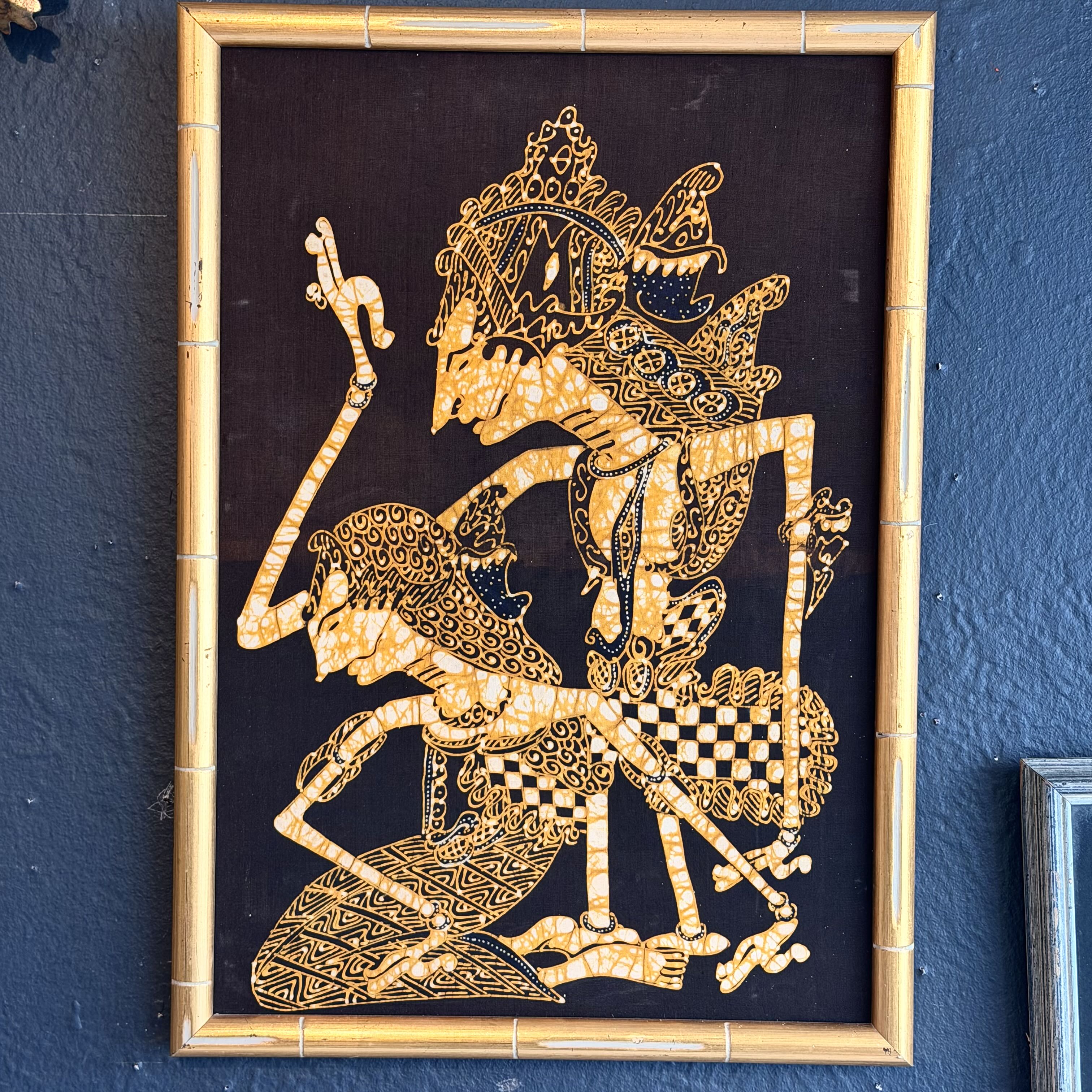 Decorative wall art of a warrior on a horse with intricate gold patterns in a wooden frame.