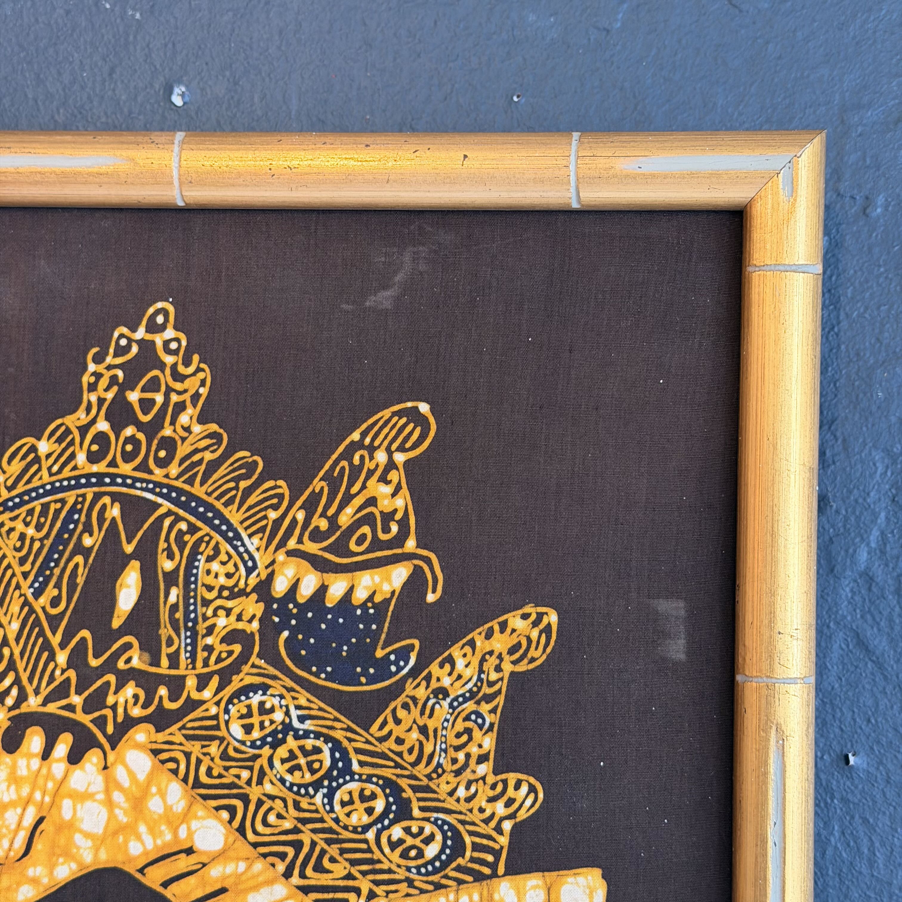 Decorative artwork with intricate patterns on a dark background, framed in bamboo.