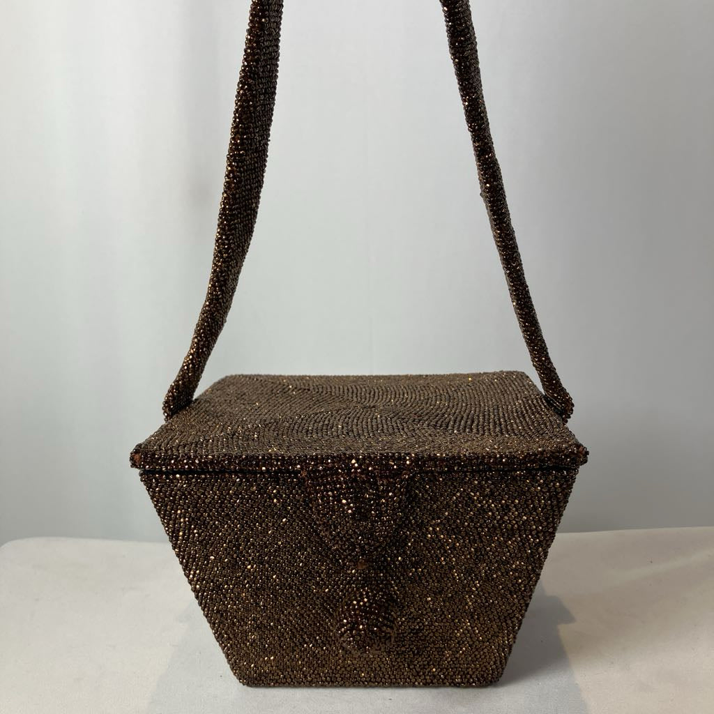 Brown beaded handbag with a strap on a light gray background