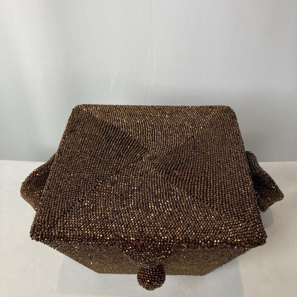 Brown beaded clutch bag on a white surface with a light gray background