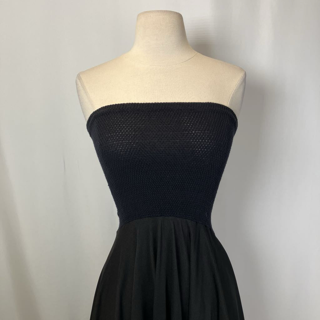Black strapless dress on a mannequin against a plain background