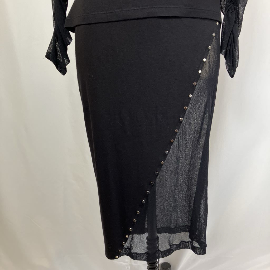 Black skirt with sheer side panel and decorative buttons on a white background