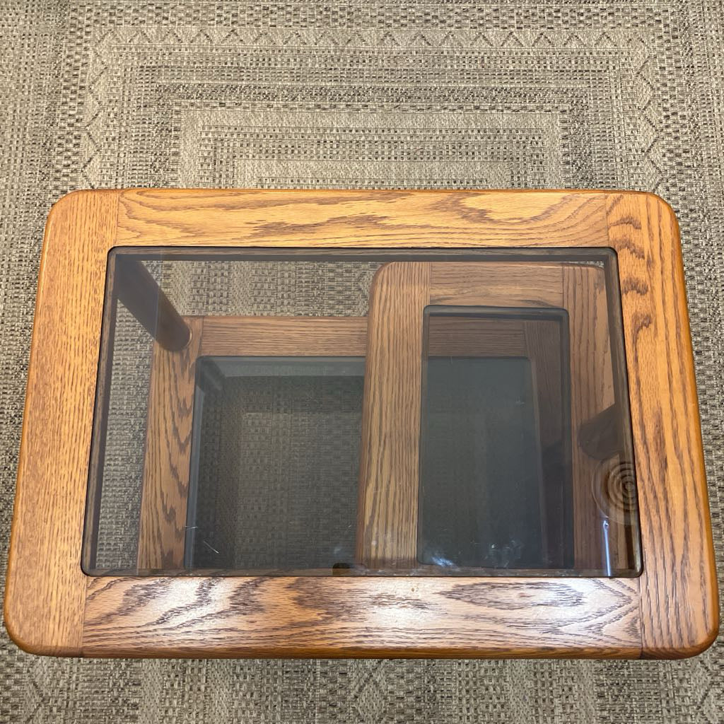 Wooden table with a glass top on a carpet.