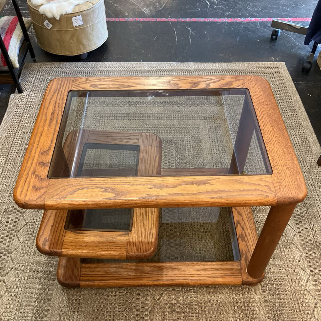 Wooden coffee table with glass top on a textured rug