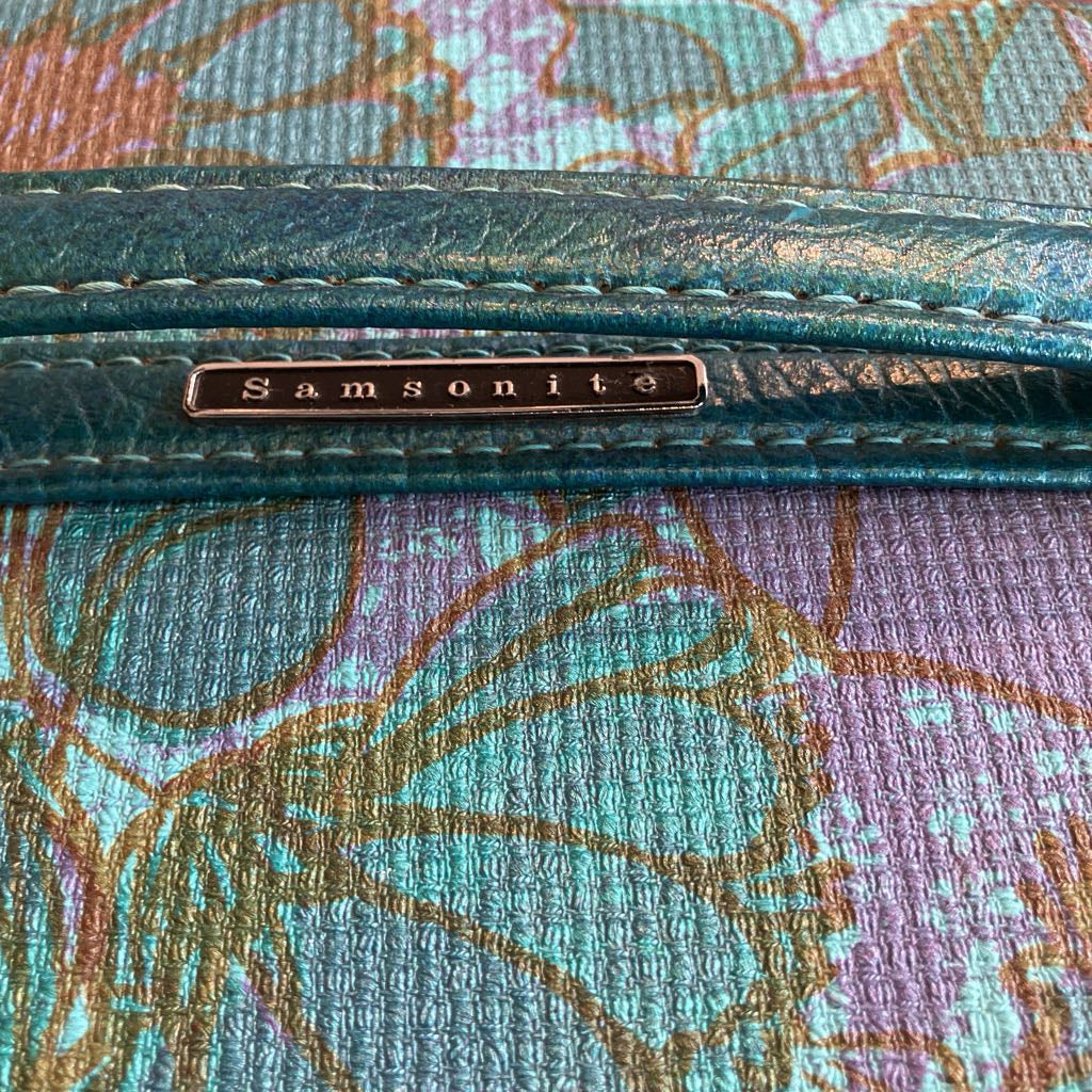 Close-up of a Samsonite suitcase with floral patterned background