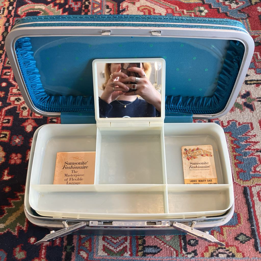 Open vintage-style suitcase with compartments on a patterned rug