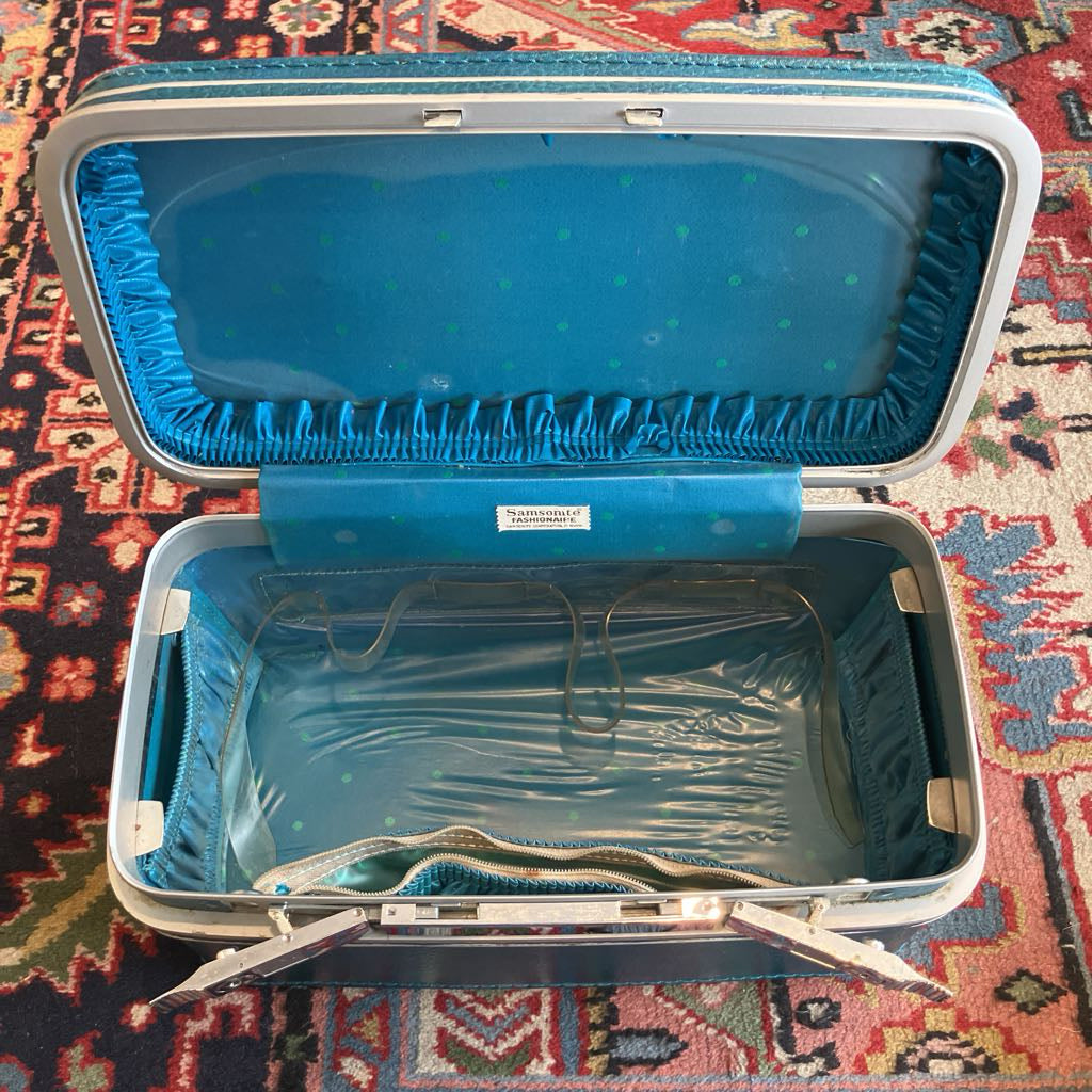 Open blue suitcase on a patterned rug