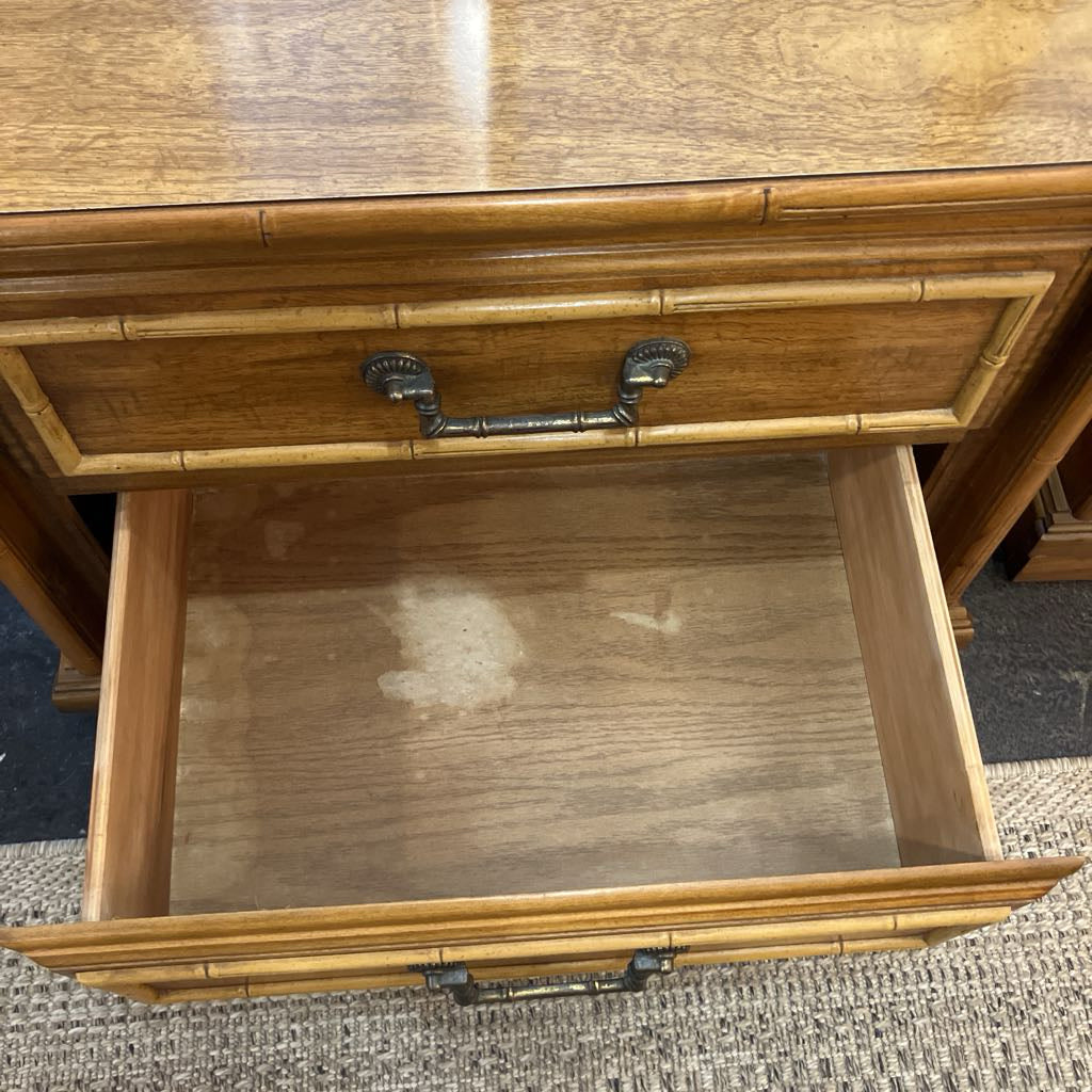 Wooden desk with an open drawer, showing wear and tear.