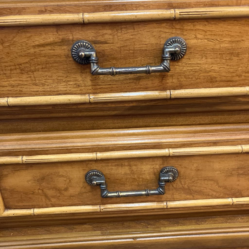 Wooden drawer with metal handles on a wooden surface