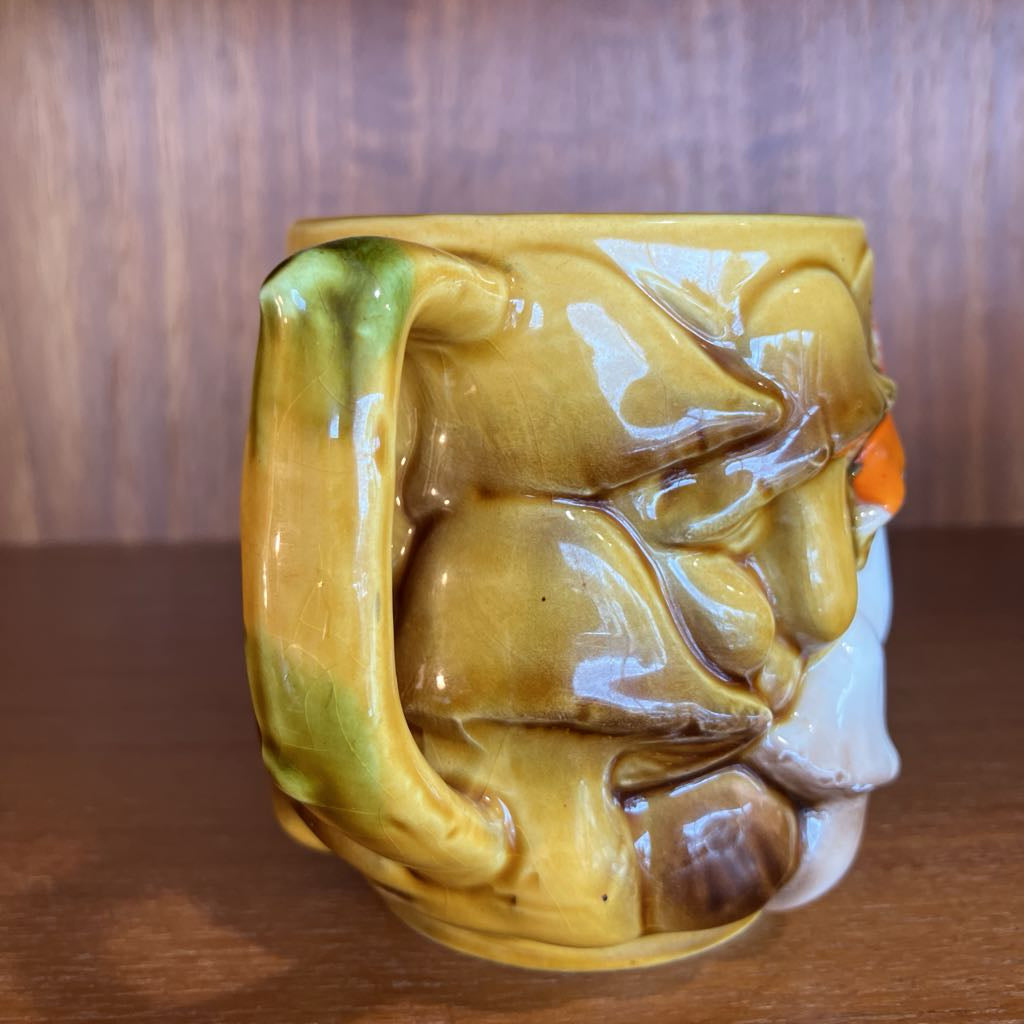 Decorative mushroom ceramic mug on a wooden surface.